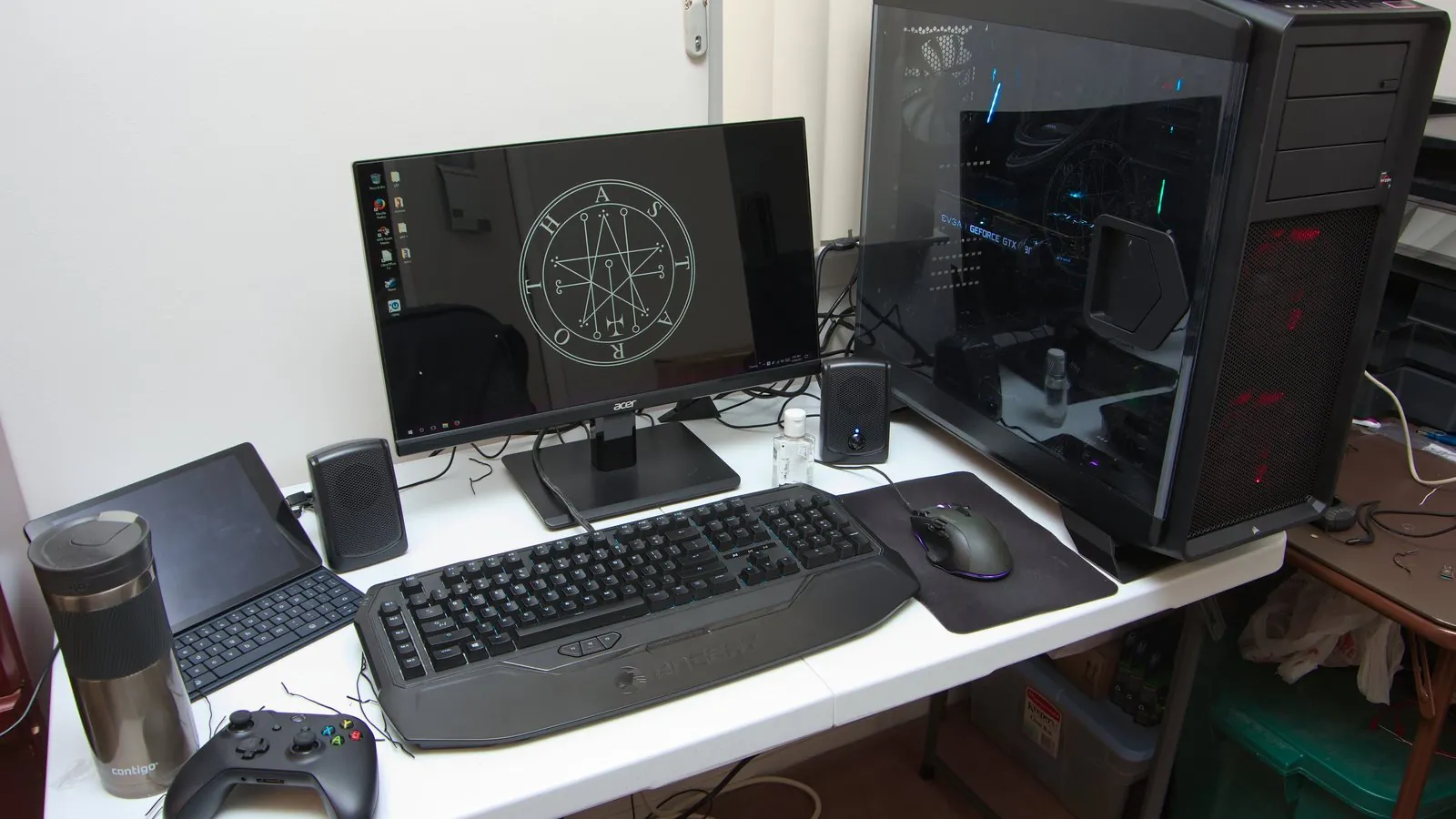 A desktop gaming setup with an Acer monitor, keyboard, mouse, and gaming PC